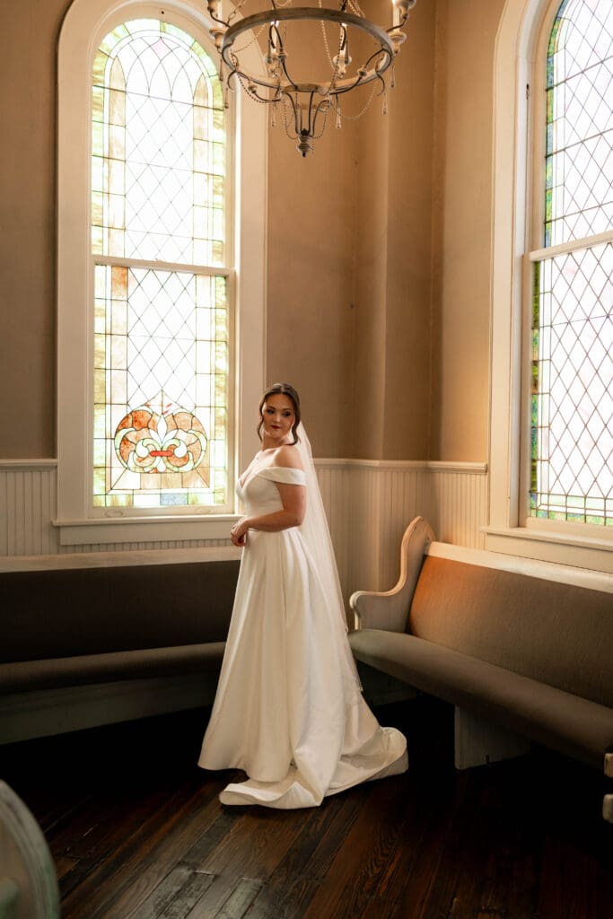 Bride posing under chandelier at The 1906 Venue in Whitesboro