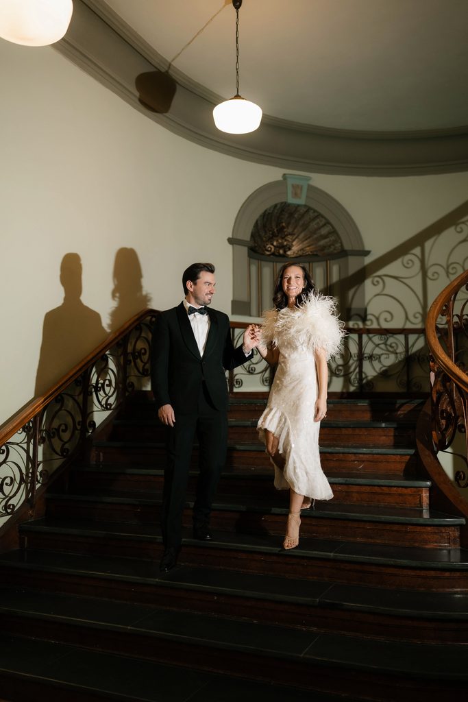 Bride and groom posing on the staircase at the Tarrant County Courthouse, one of the best wedding venues in Dallas Fort Worth