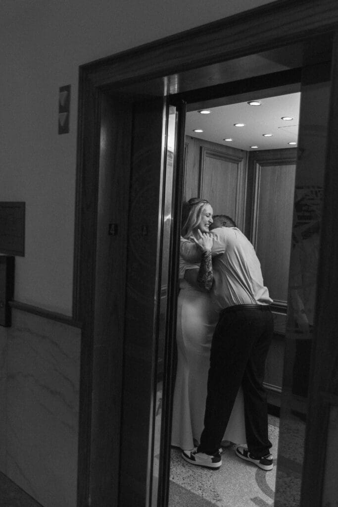 Bride and groom having fun and kissing in the Tarrant County Courthouse elevator during their elopement.