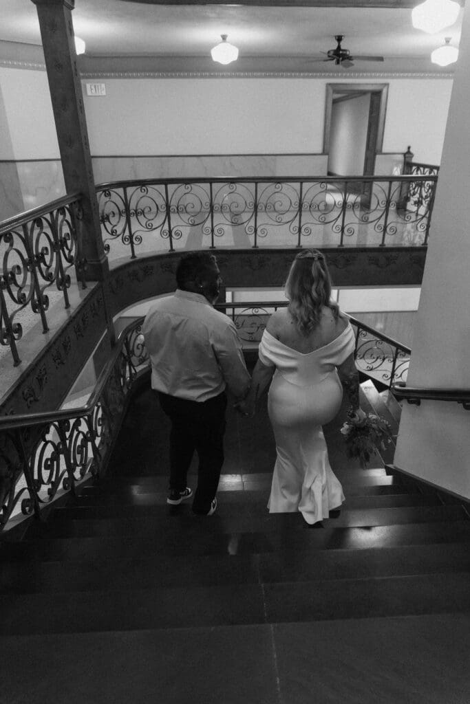 Bride and groom descending the stairs during their intimate Tarrant County Courthouse wedding.