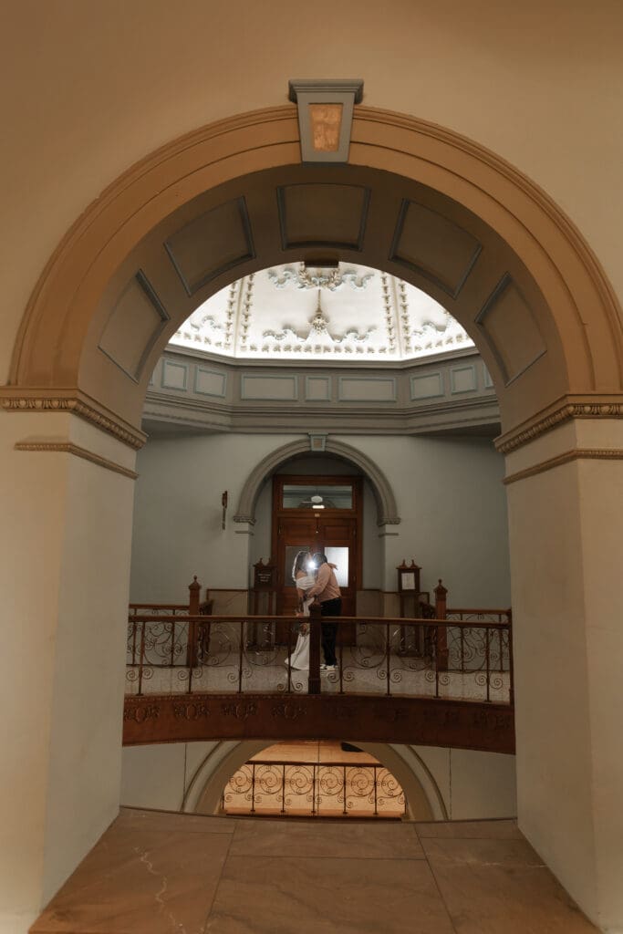 Couple captured kissing and interacting during their intimate Fort Worth courthouse wedding indoors.