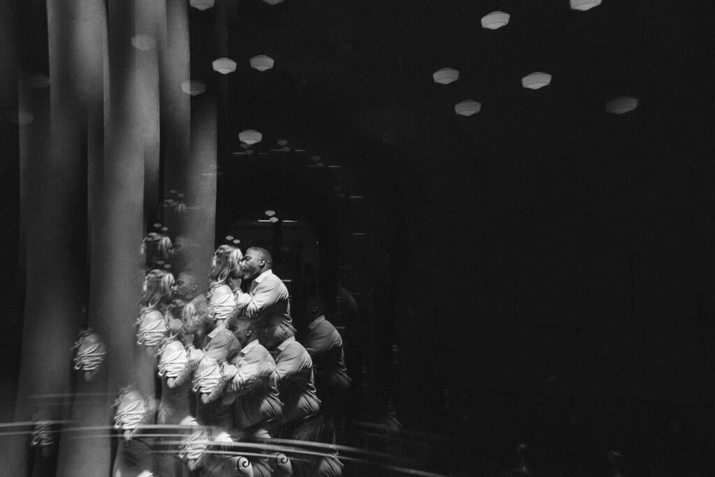 Moody, creative portrait of a couple kissing inside the Tarrant County Courthouse during their elopement.