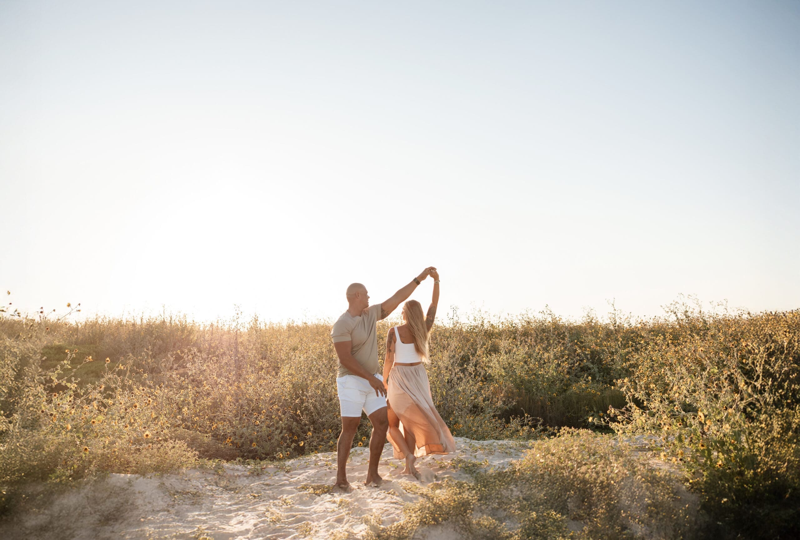 Corpus Christi couple dancing on the sand dunes at Lively Beach during sunset anniversary photo session