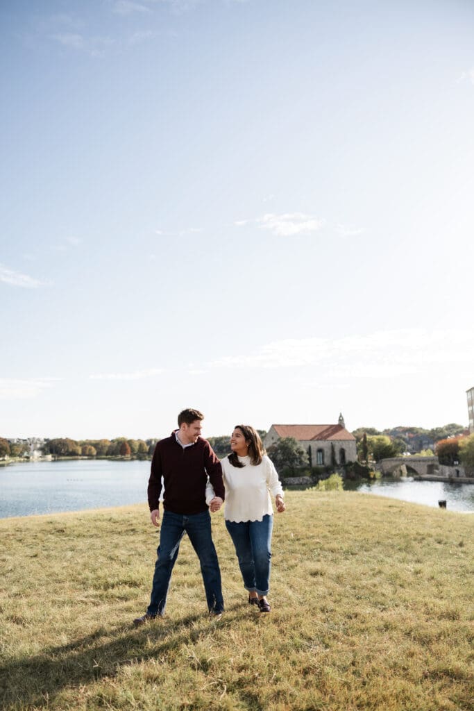 Couple walking hand in hand during Adriatica Village engagement photos in McKinney, TX