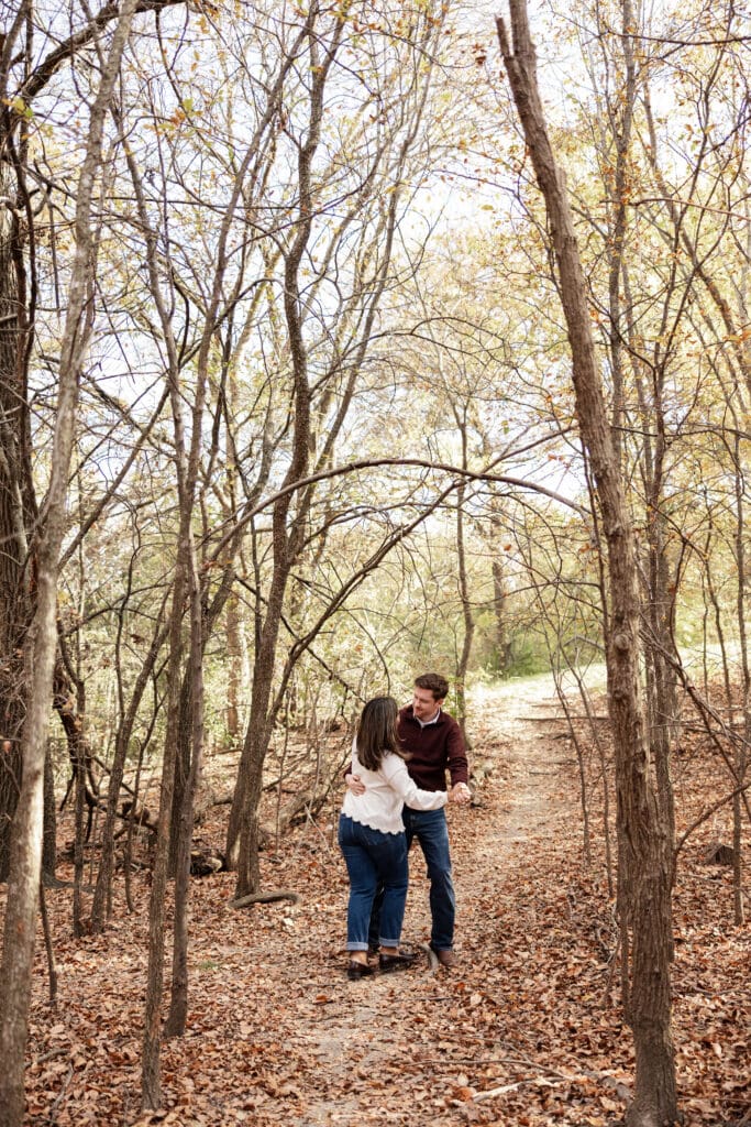 Couple walking hand in hand during Adriatica Village engagement photos in McKinney, TX