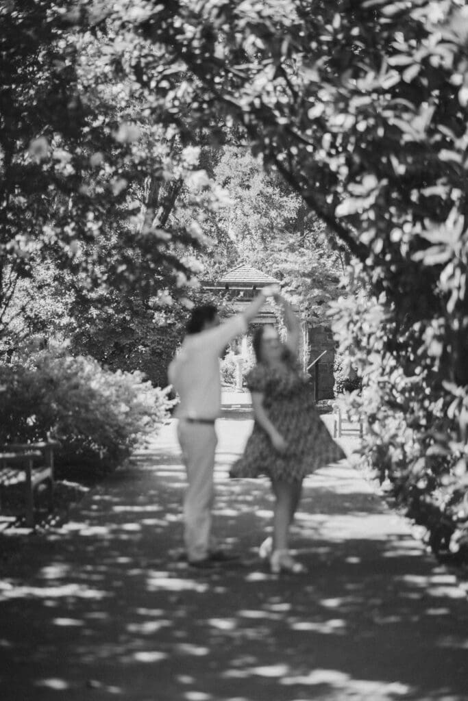 Engaged couple dancing under a magnolia tree at the Fort Worth Botanic Gardens