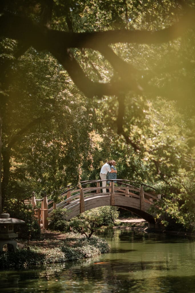 Engaged couple embracing on a bridge in the Japanese Gardens at the Fort Worth Botanic Gardens