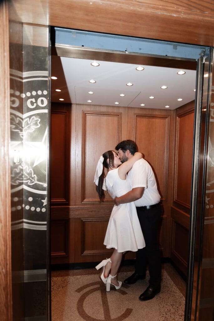 Couple kissing inside the courthouse elevator during their Fort Worth engagement photoshoot in downtown  Fort Worth