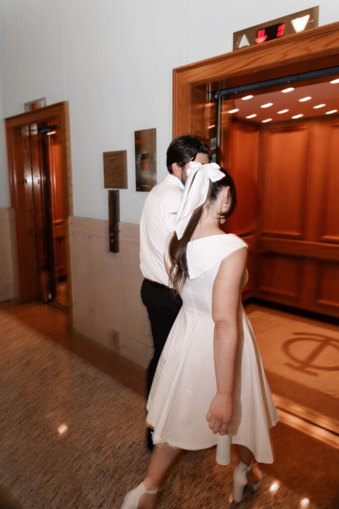 Couple approaching an elevator together at the Tarrant County Courthouse, captured during their engagement session.