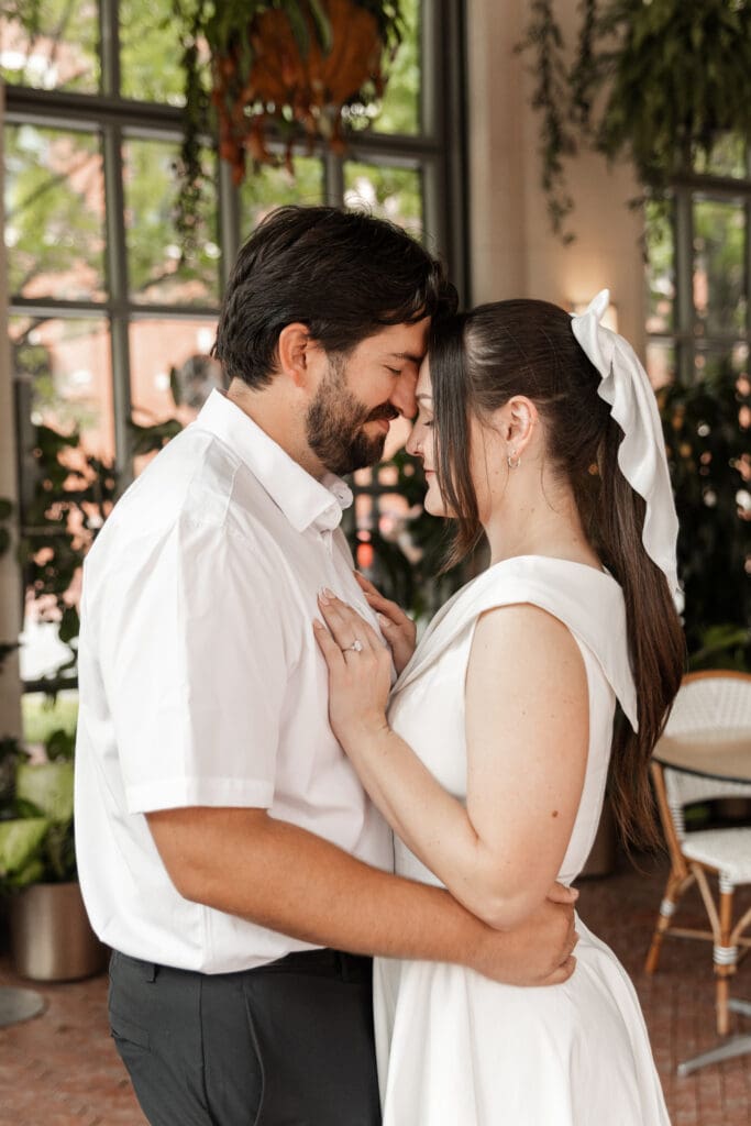 Couple embracing in the Sundance Square Pavilion greenhouse during their downtown Fort Worth engagement session
