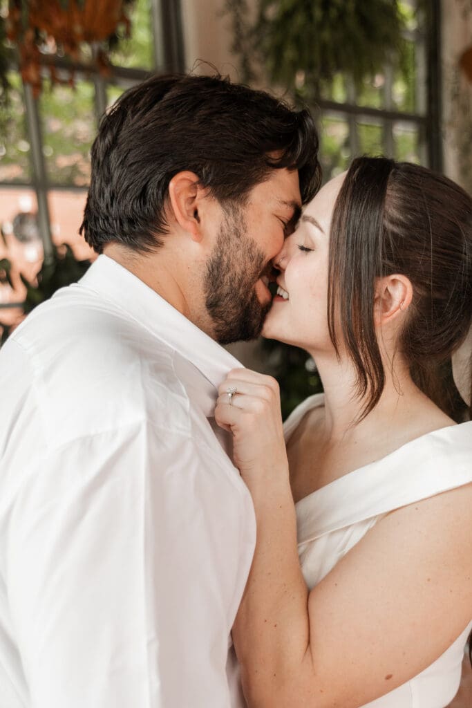 Couple embracing in the Sundance Square Pavilion greenhouse during their downtown Fort Worth engagement session
