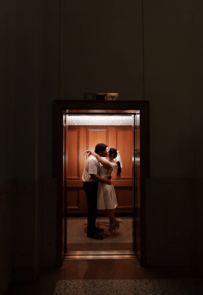 Couple kissing inside the courthouse elevator during their Fort Worth engagement photoshoot in downtown  Fort Worth