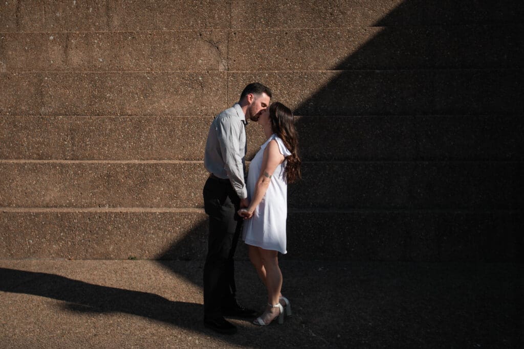 Engaged couple at the Water Gardens, Fort Worth, embracing each other during golden-hour engagement photos