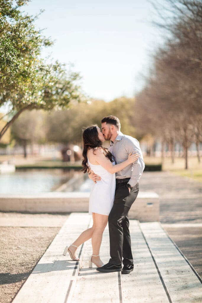 Engaged couple at Kimbell Art Museum, Fort Worth, embracing and cuddling