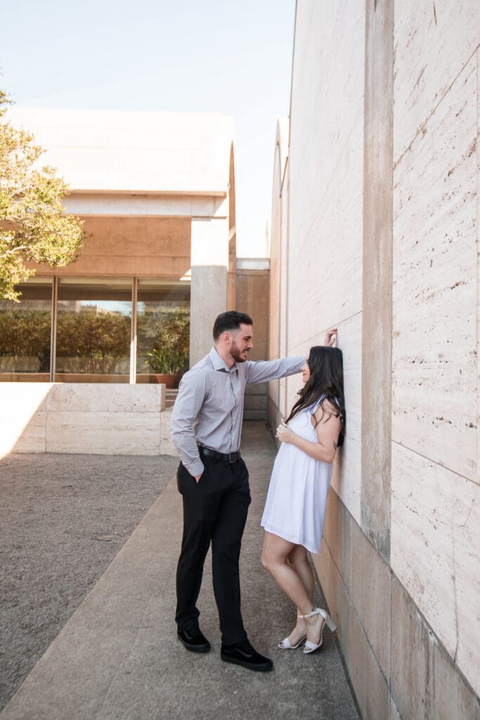 Engaged couple at Kimbell Art Museum, Fort Worth, embracing and flirting with each other