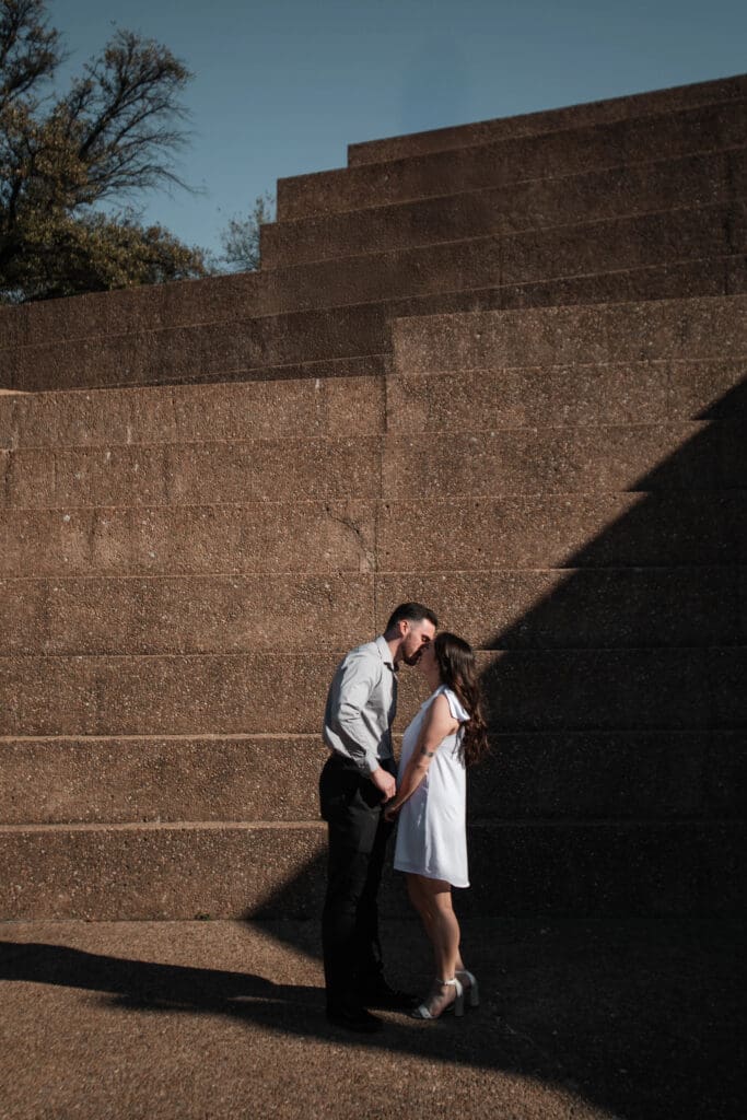 Engaged couple at the Water Gardens, Fort Worth, enjoying golden-hour engagement photos