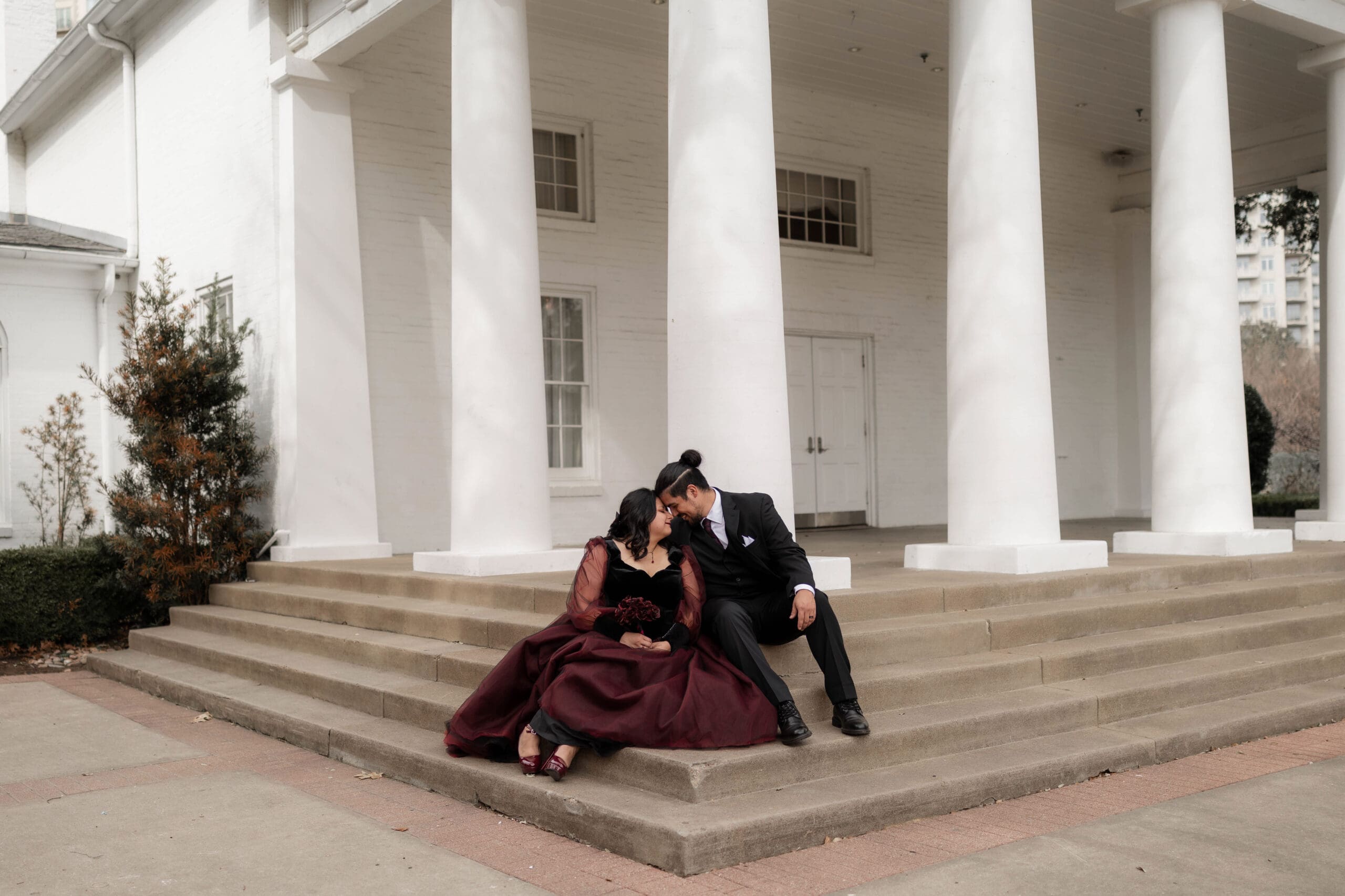 Romantic portrait of Esmeralda and Hector in front of Arlington Hall during their Dallas courthouse wedding