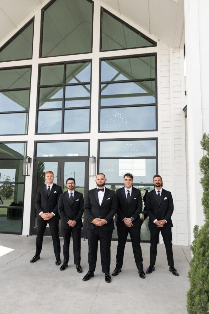 Groom's portraits with wedding party at The Gardenia Venue in Valley View, TX