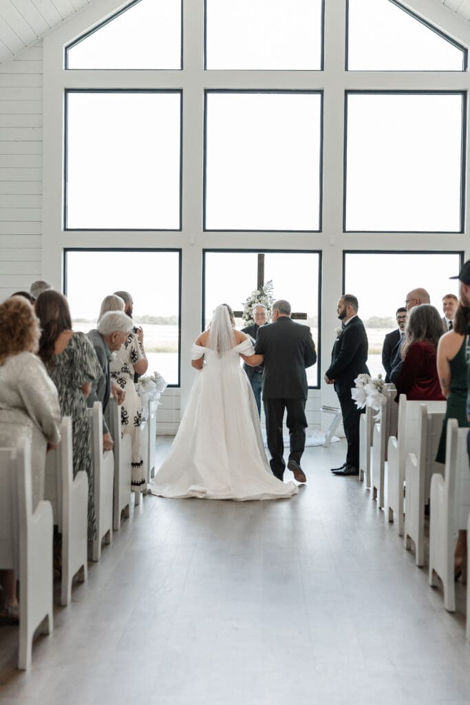 Father walking bride down the aisle in the chapel at The Gardenia Venue in Valley View, TX