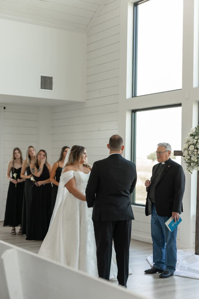 Bride and groom exchanging vows in the chapel at The Gardenia Venue in Valley View, TX