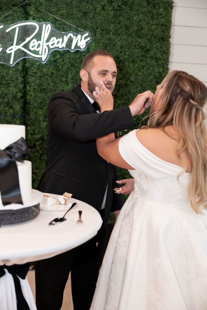 Bride and groom cutting wedding cake at The Gardenia Venue in Valley View, TX