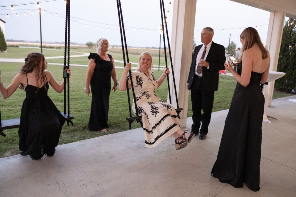 Wedding guests swinging at The Gardenia Venue in Valley View, TX