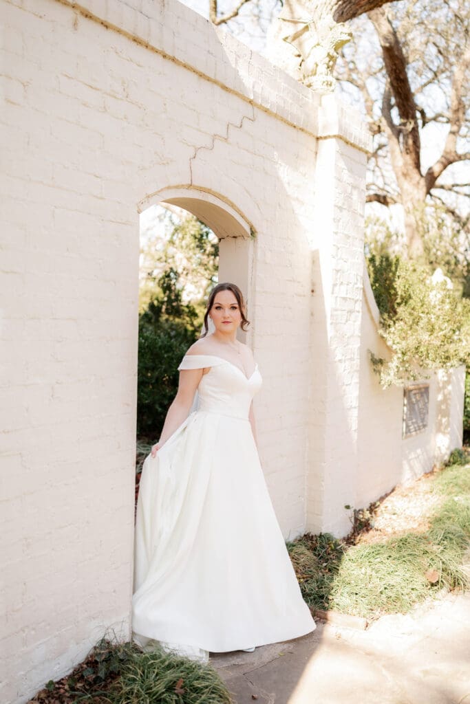 Bride leaning against brick archway