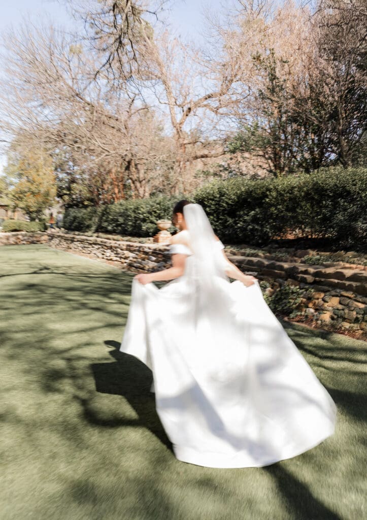 Blurred motion bridal portrait of a bride running across lawn at Chandor Gardens in Weatherford, TX