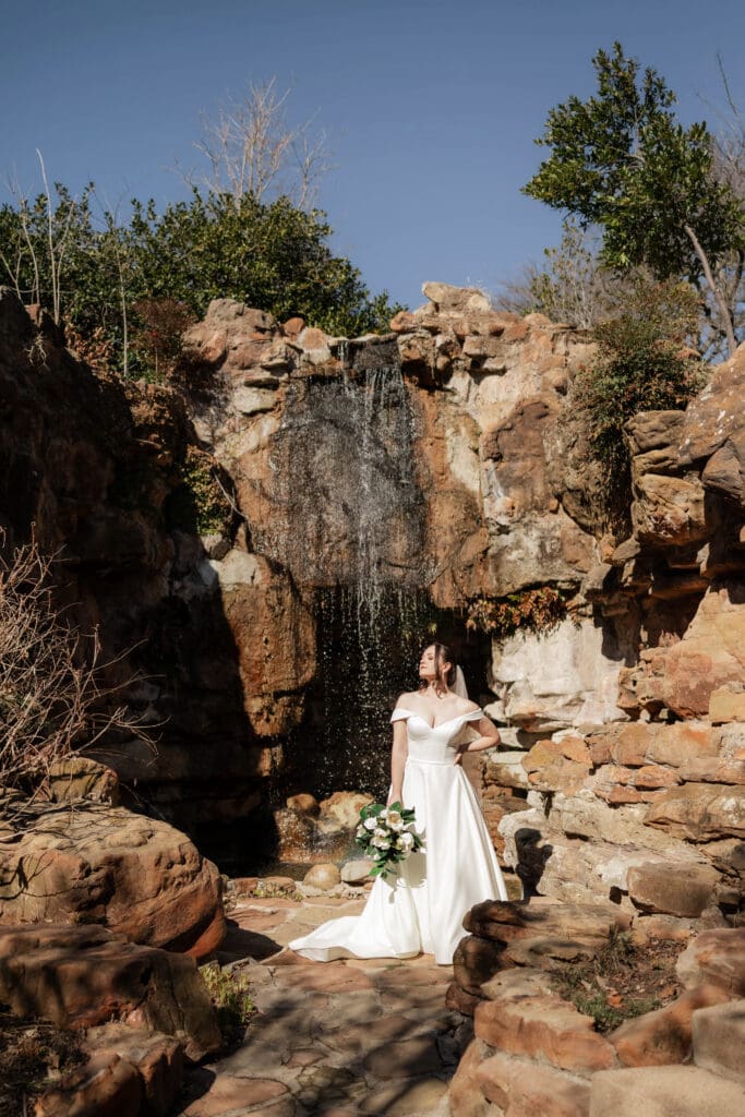 Dynamic shot of bride by the waterfall at Chandor Gardens in Weatherford, TX