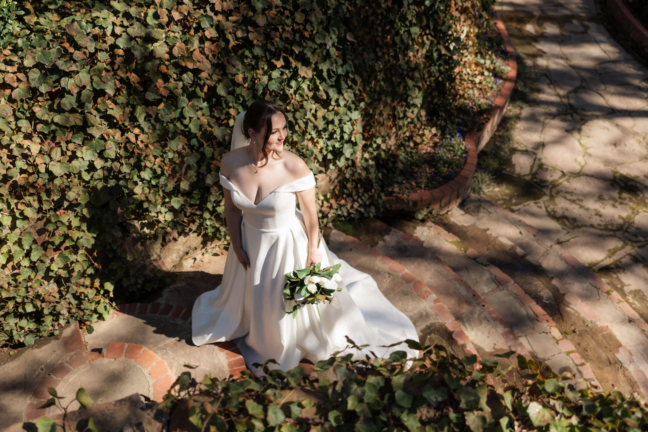 Moody, cinematic photo of bride along stone steps at Chandor Gardens