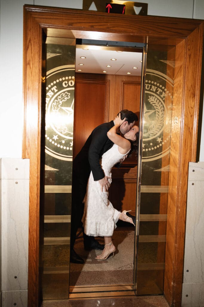 Woman and man cuddling in the Fort Worth courthouse elevator during their Fort Worth engagement session