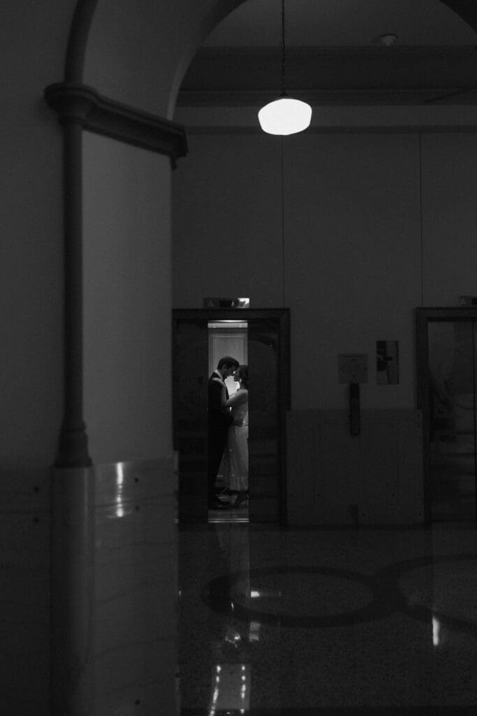 Woman and man cuddling in the Fort Worth courthouse elevator during their Fort Worth engagement session