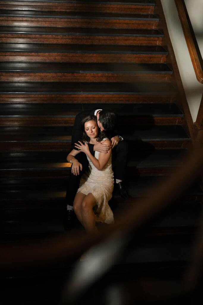 Woman and man cuddling on steps in the Fort Worth courthouse during their Fort Worth engagement session
