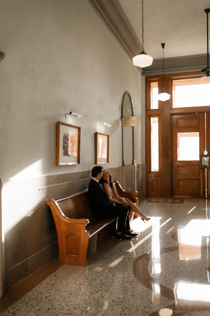 Woman and man cuddling on in the Fort Worth courthouse during their Fort Worth engagement session