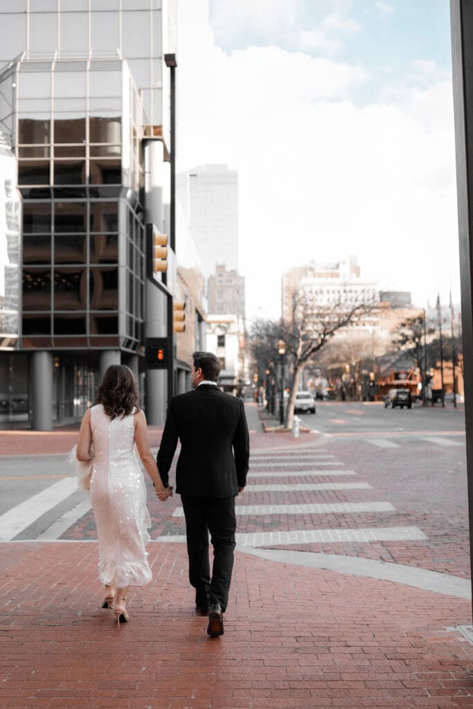 Man and woman walking across the street in downtown Fort Worth