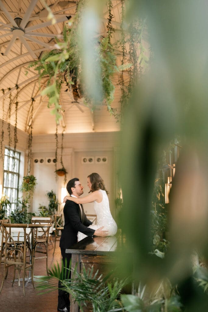 Woman and man cuddling inside the Sundance Square Pavilion greenhouse during their photo session