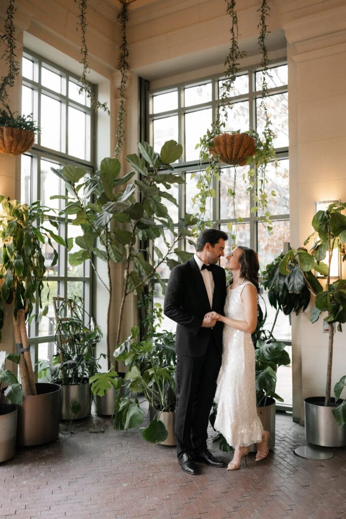 Woman and man cuddling inside the Sundance Square Pavilion greenhouse during their photo session