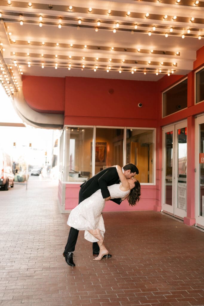 Woman and man dancing under the cinema lights in downtown Fort Worth during their photo session