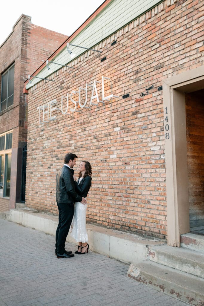 Woman and man cuddling outside the The Usual bar in Fort Worth