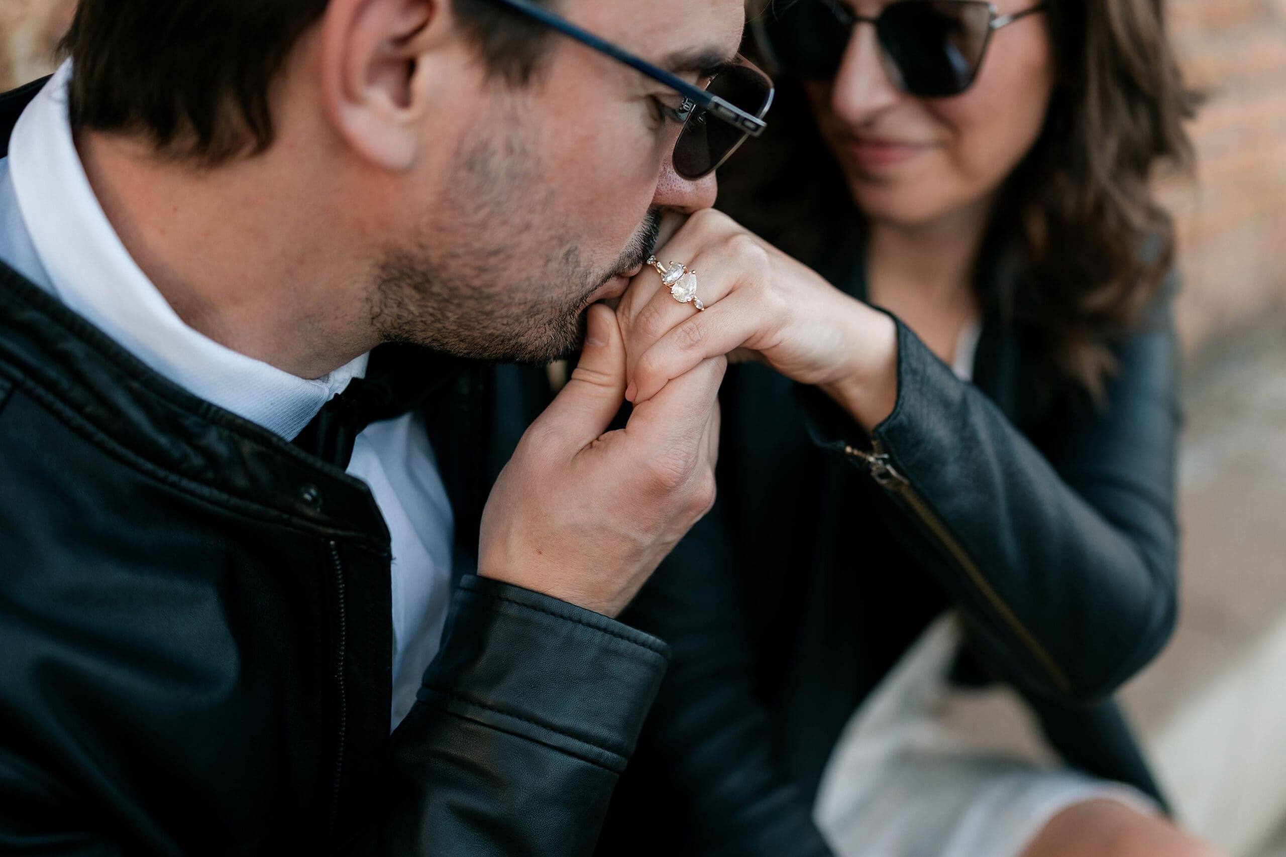 Woman and man cuddling, the man kissing the woman's hand