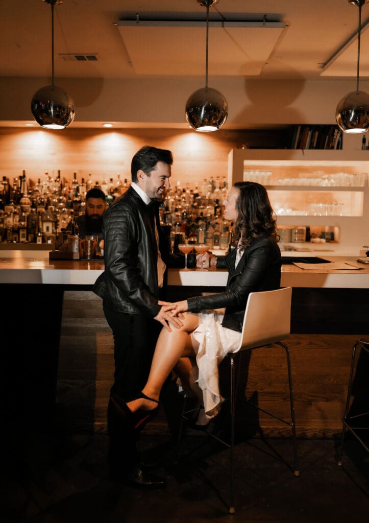 Direct flash photo of Woman and man cuddling at the bar during their engagement session in Fort Worth