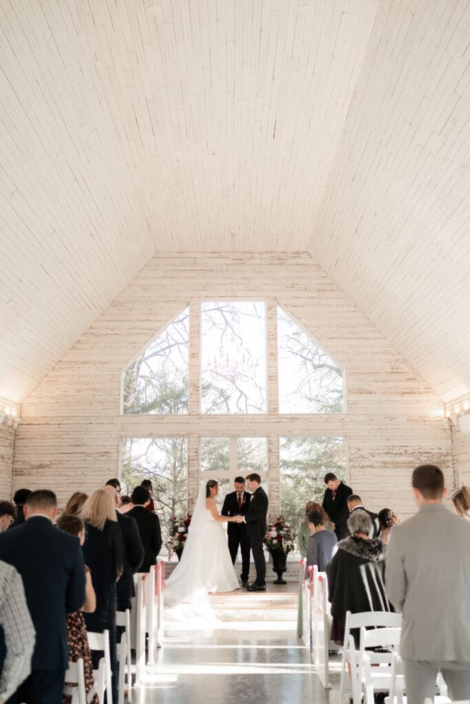 Bride and groom at altar exchanging vows in the little white chapel at Soli Deo Gloria weddings and events in Decatur