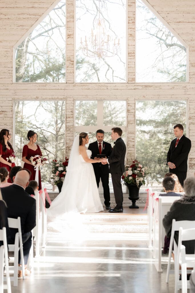 Bride and groom at altar exchanging vows in the little white chapel at Soli Deo Gloria weddings and events in Decatur