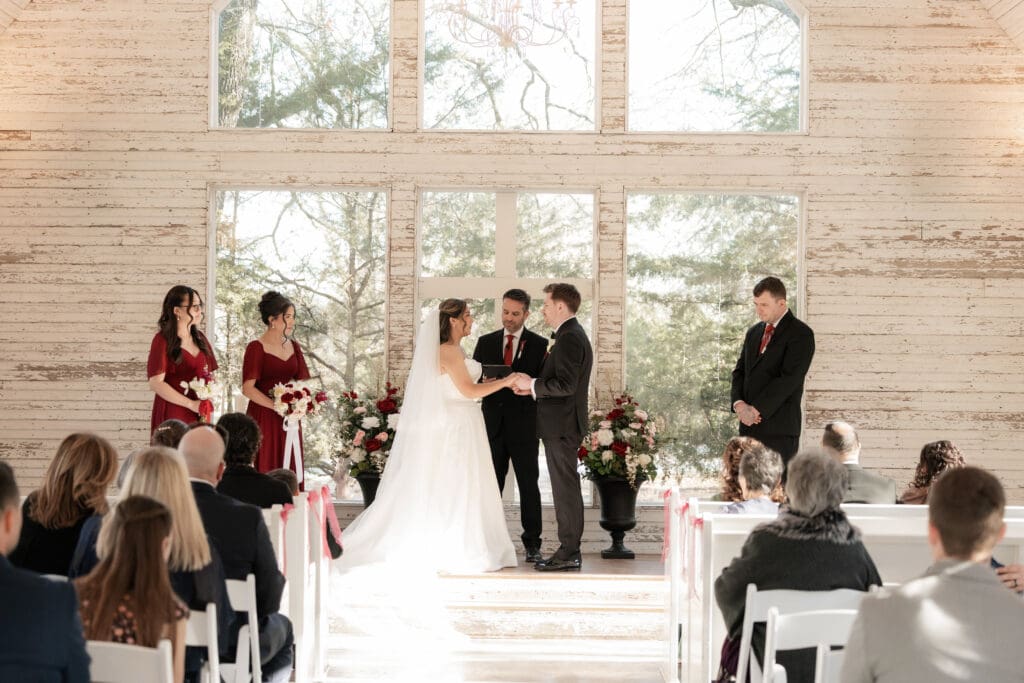 Bride and groom at altar exchanging vows in the little white chapel at Soli Deo Gloria weddings and events in Decatur