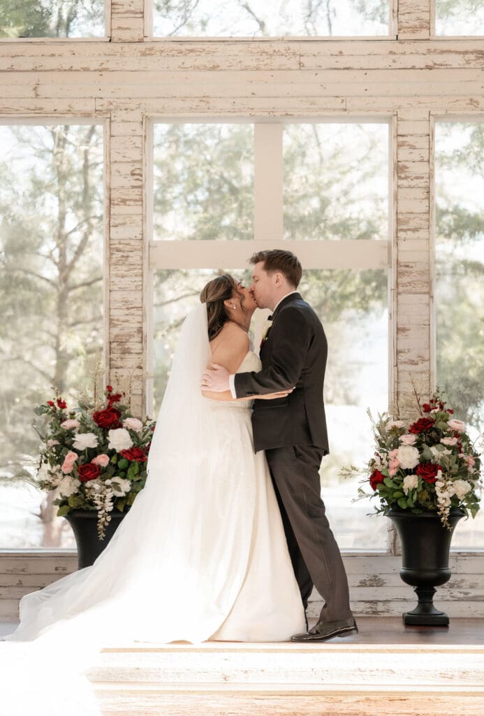 Bride and groom at altar kissing in the little white chapel at Soli Deo Gloria weddings and events in Decatur