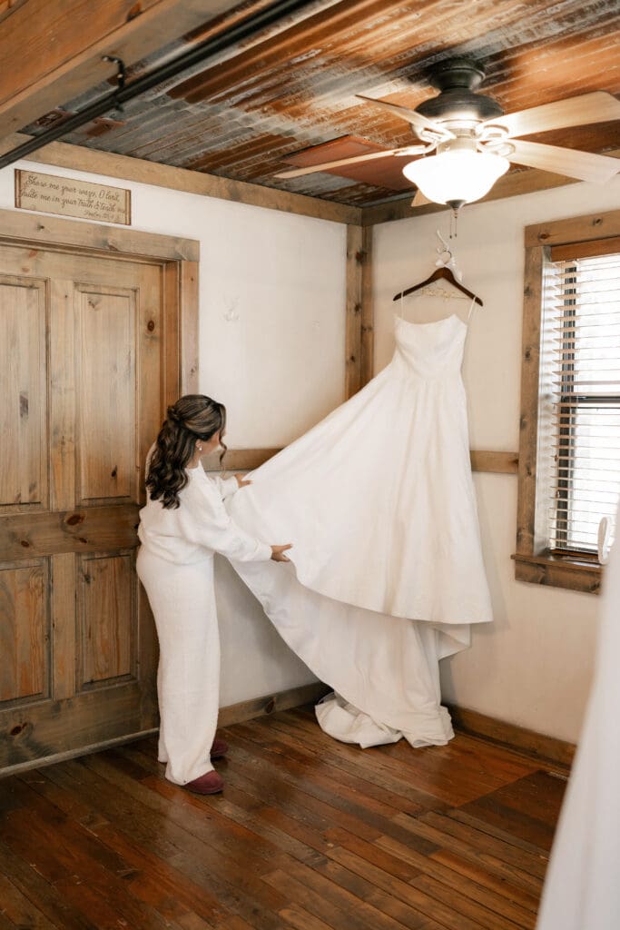 Bride admiring her dress before putting it on