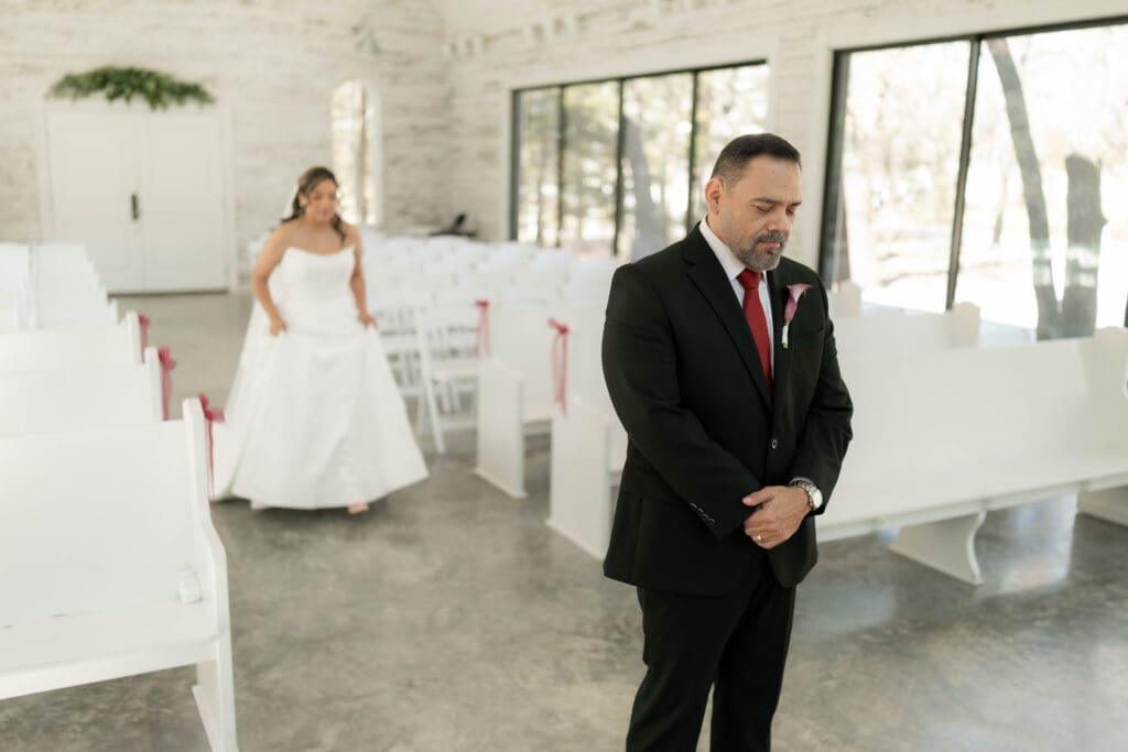 Bride doing a first look with her father in the chapel