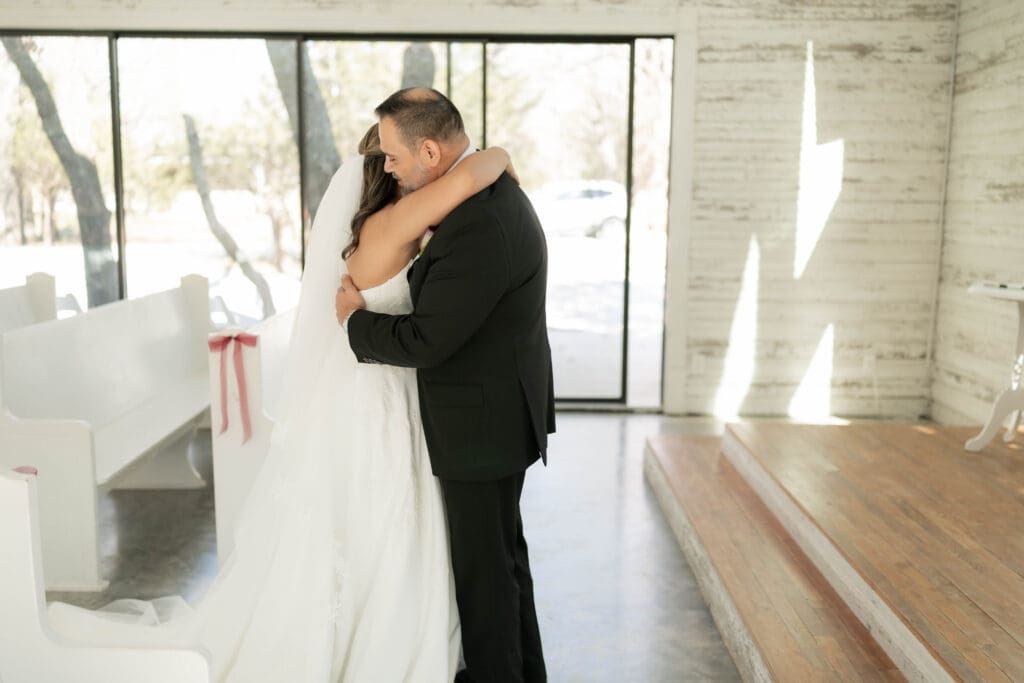 Bride doing a first look with her father in the chapel