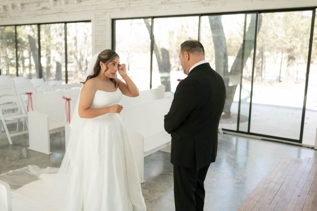 Bride doing a first look with her father in the chapel