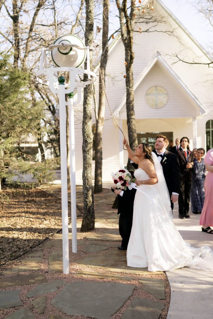 Bride ringing the chapel bell outside the chapel at Soli Deo Gloria weddings and events